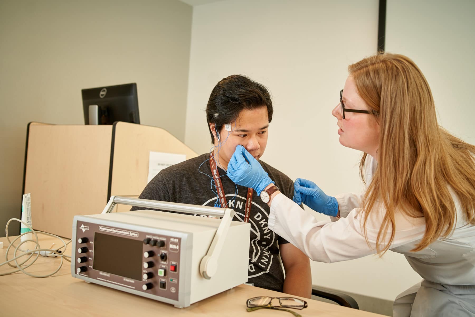A doctor attaches electrodes to a patient